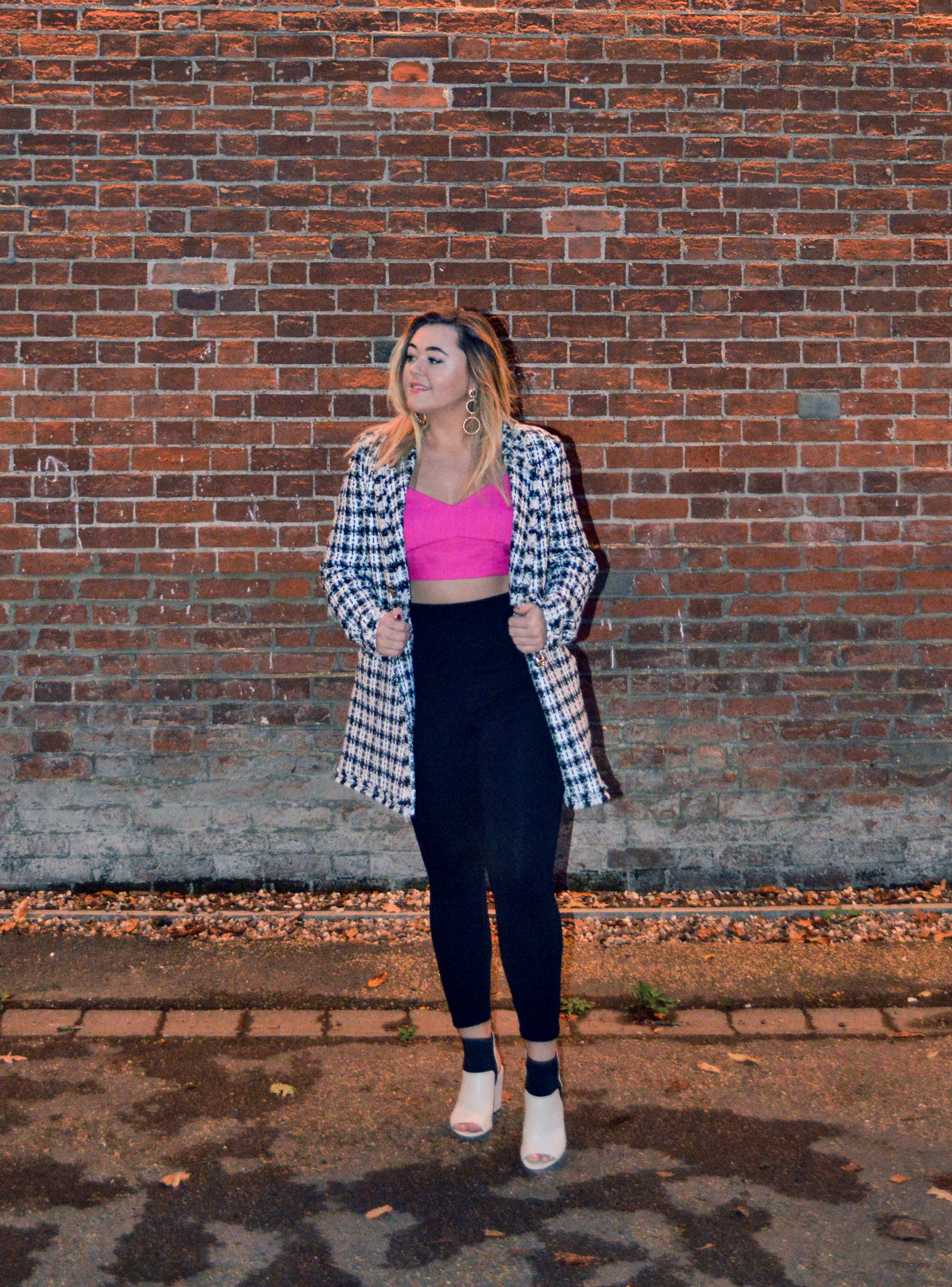 Hannah wears a fuschia pink bralet top with black leggins and black and white check bouclé jacket by River Island